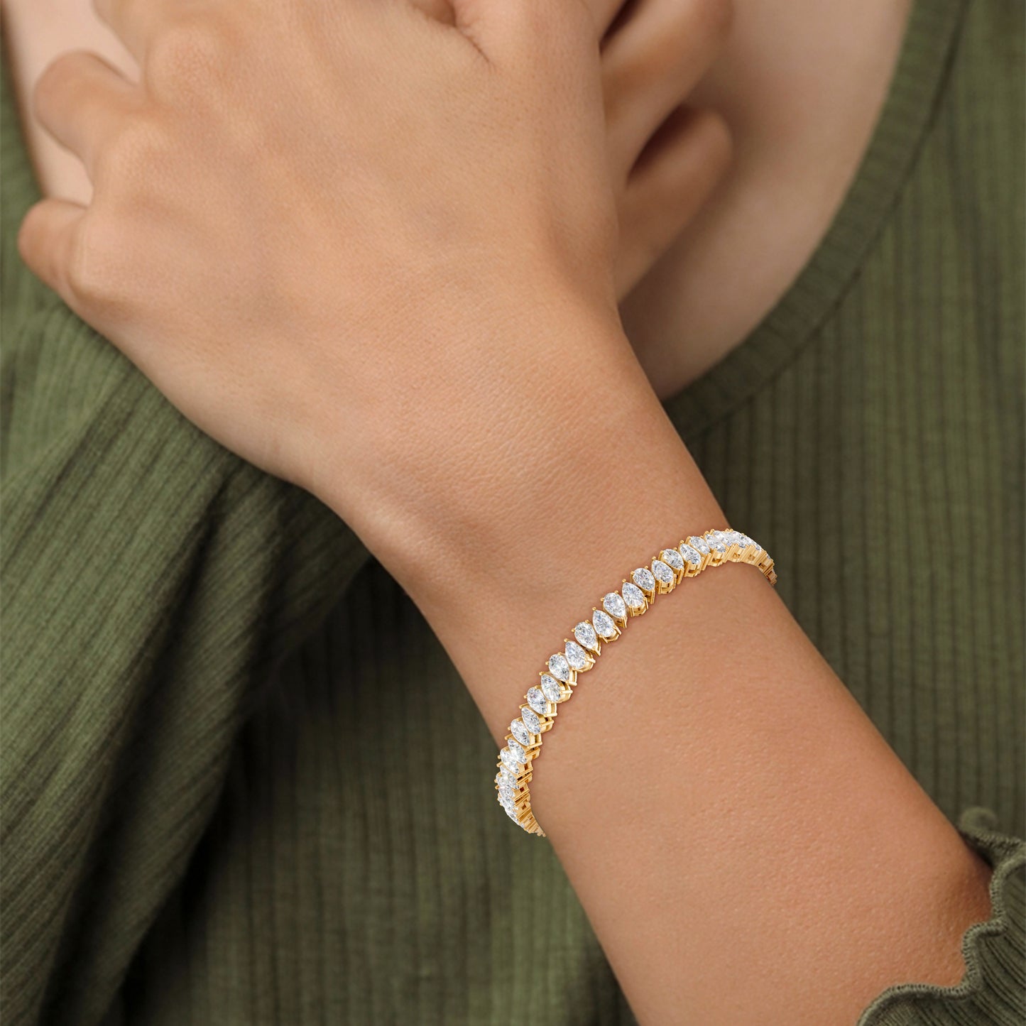 Close-up of the Pear Radiance Bracelet on a model, detailing the 7.95 ct pear-cut diamonds’ brilliance and the polished 18K yellow gold setting, highlighting the signature sparkle.
